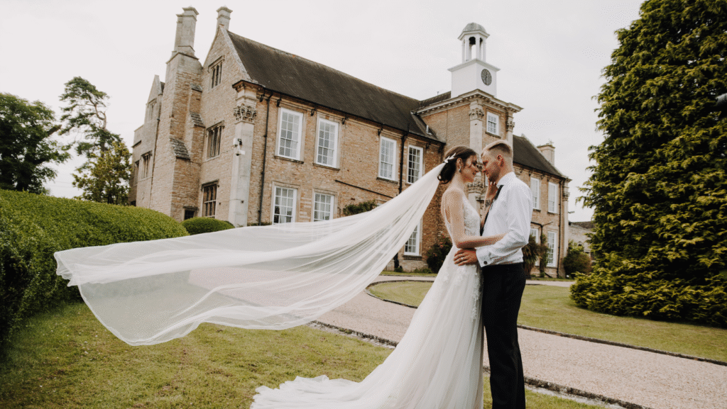 Newlywed portraits with the manor as backdrop at Hinwick Hall.